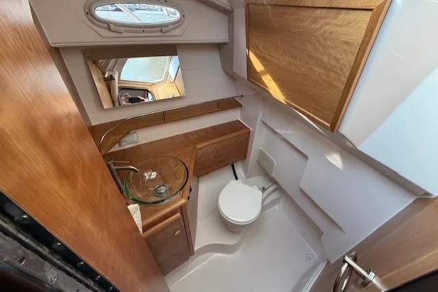 Slide: The Image of 2026 Cutwater C-288 CB boat bathroom with wood cabinetry and glass sink. - 7