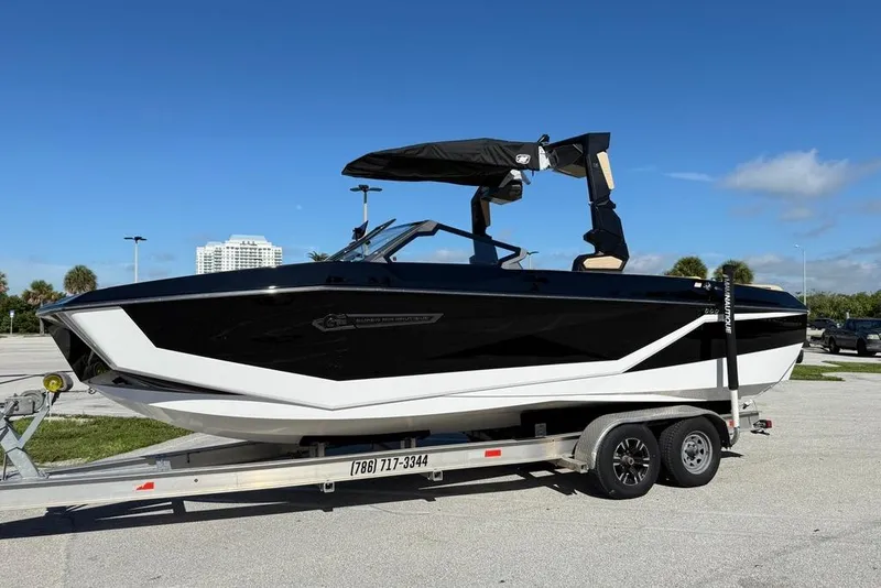 The Image of 2026 Nautique Super Air Nautique G25 Coastal Edition boat on trailer, sunny day. - 1
