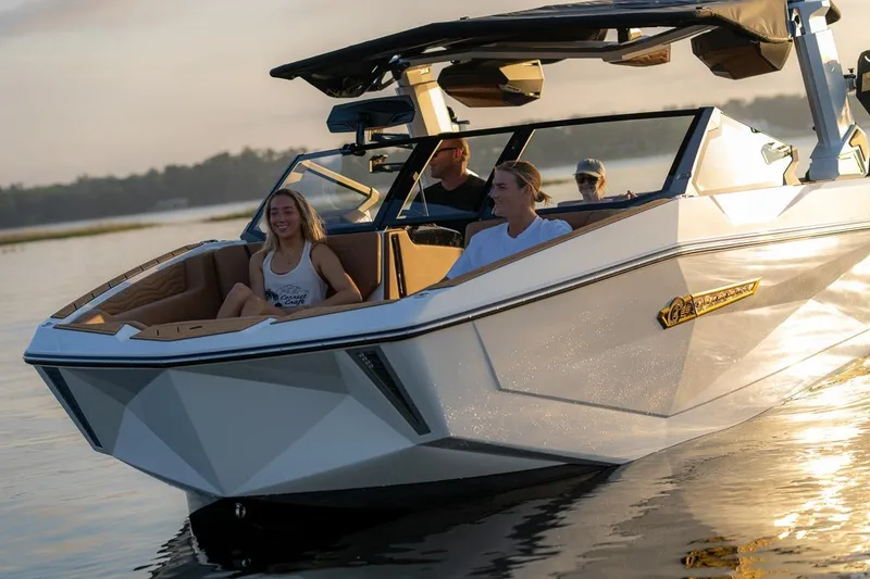 Slide: The Image of 2026 Nautique Super Air Nautique G25 Coastal Edition cruising with passengers at sunset. - 10