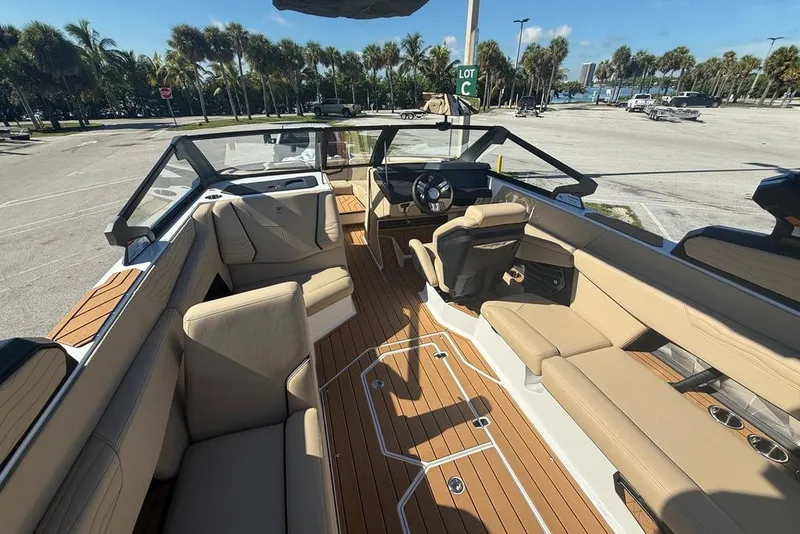 Slide: The Image of 2026 Nautique Super Air Nautique G25 Coastal Edition interior with tan seating and wood flooring. - 5