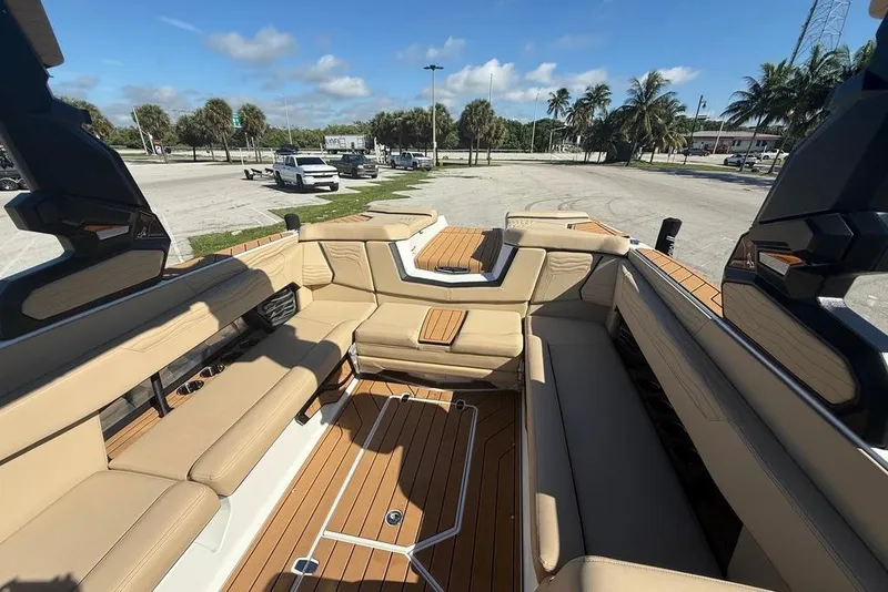 Slide: The Image of 2026 Nautique Super Air Nautique G25 Coastal Edition interior with tan seating and teak flooring. - 8