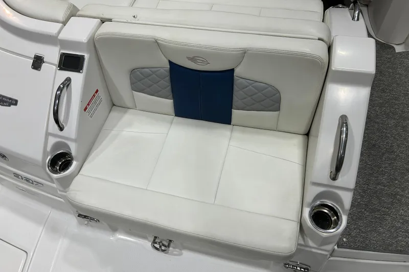 Slide: The Image of 2012 Chaparral 327 SSX boat seat with white and blue upholstery, featuring cup holders. - 111