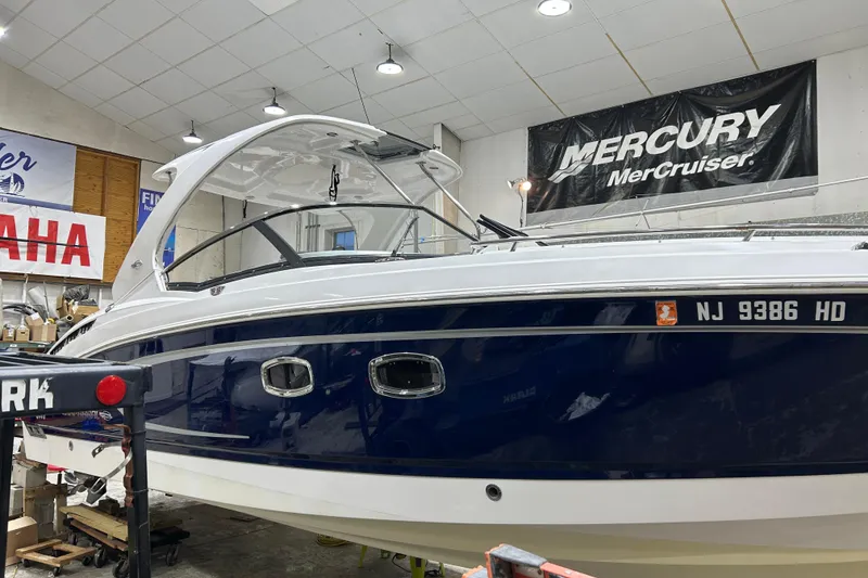 The Image of 2012 Chaparral 327 SSX boat in showroom with Yamaha and Mercury banners. - 12
