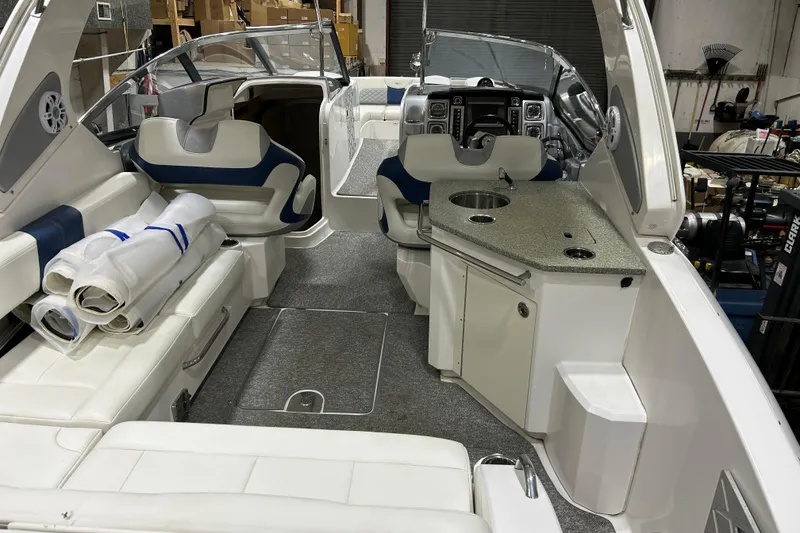 Slide: The Image of 2012 Chaparral 327 SSX boat interior with seating, kitchenette, and storage. - 18
