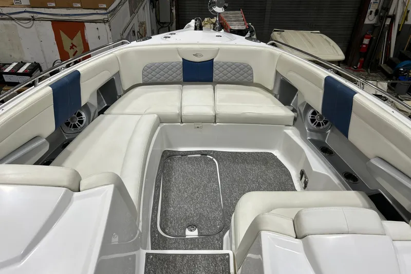 Slide: The Image of 2012 Chaparral 327 SSX boat interior with white and blue seating, speakers, and carpeted floor. - 22
