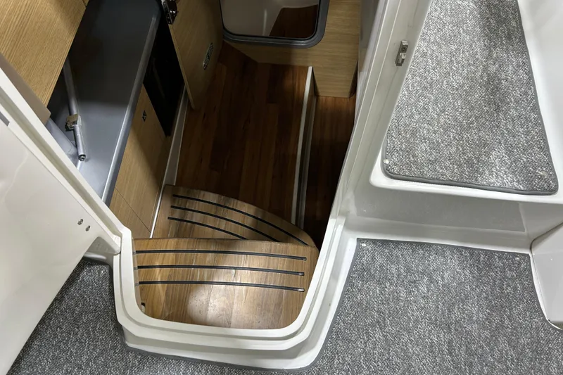 Slide: The Image of Interior view of 2012 Chaparral 327 SSX boat with wooden steps and carpeted flooring. - 32