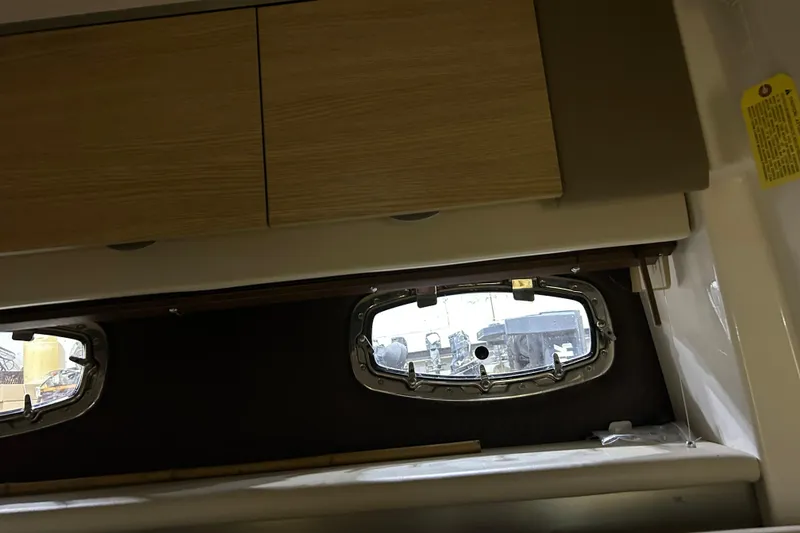 Slide: The Image of Interior view of 2012 Chaparral 327 SSX boat with wooden cabinets and porthole window. - 36