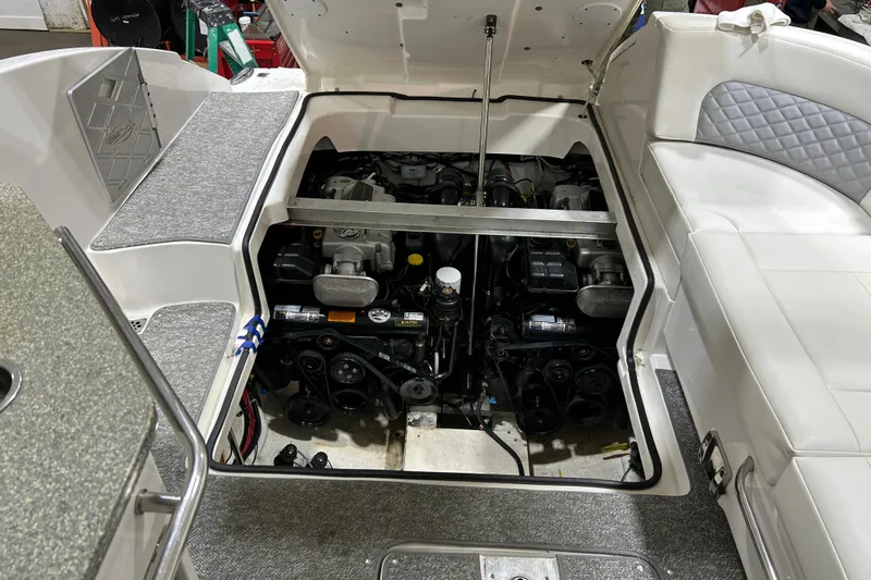 Slide: The Image of Open engine compartment of a 2012 Chaparral 327 SSX boat, showcasing detailed mechanics. - 52