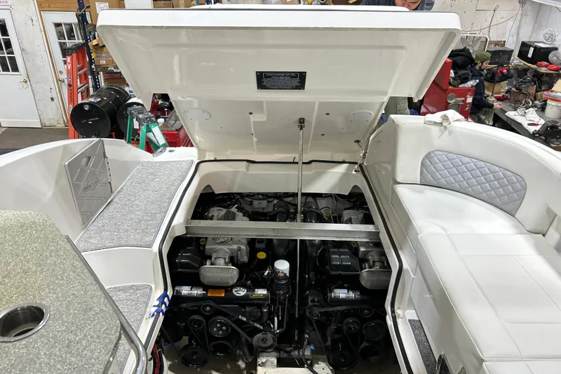 Slide: The Image of 2012 Chaparral 327 SSX boat engine compartment with open hatch in a workshop setting. - 54