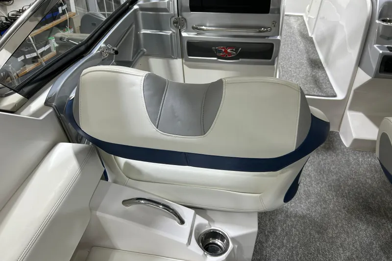 Slide: The Image of 2012 Chaparral 327 SSX boat interior with white and blue seating, cup holder, and sleek design. - 69