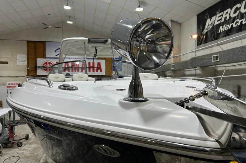 Slide: The Image of 2012 Chaparral 327 SSX boat in showroom, featuring spotlight and Yamaha signage. - 78