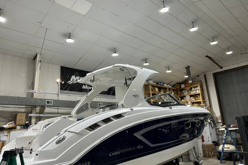 Slide: The Image of 2012 Chaparral 327 SSX boat in a well-lit indoor storage facility. - 79