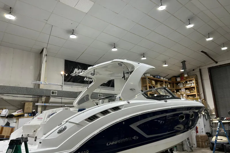 Slide: The Image of 2012 Chaparral 327 SSX boat in a well-lit workshop, surrounded by shelves and equipment. - 80