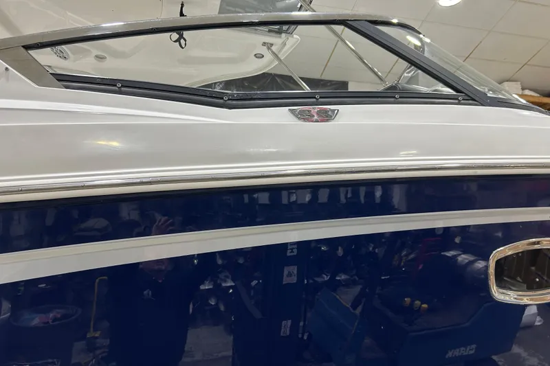 Slide: The Image of 2012 Chaparral 327 SSX boat with sleek blue and white exterior design. - 81