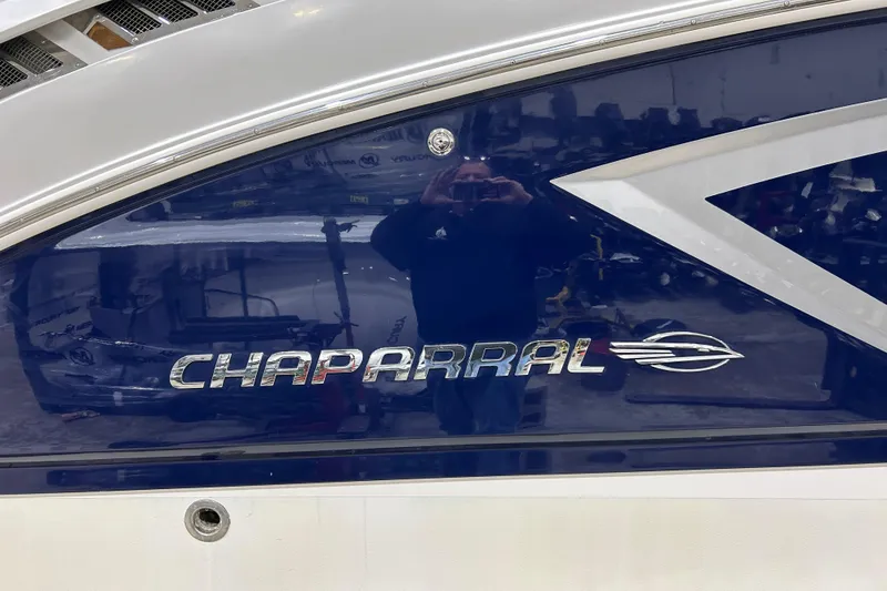 Slide: The Image of 2012 Chaparral 327 SSX boat with reflective blue and silver logo. - 82