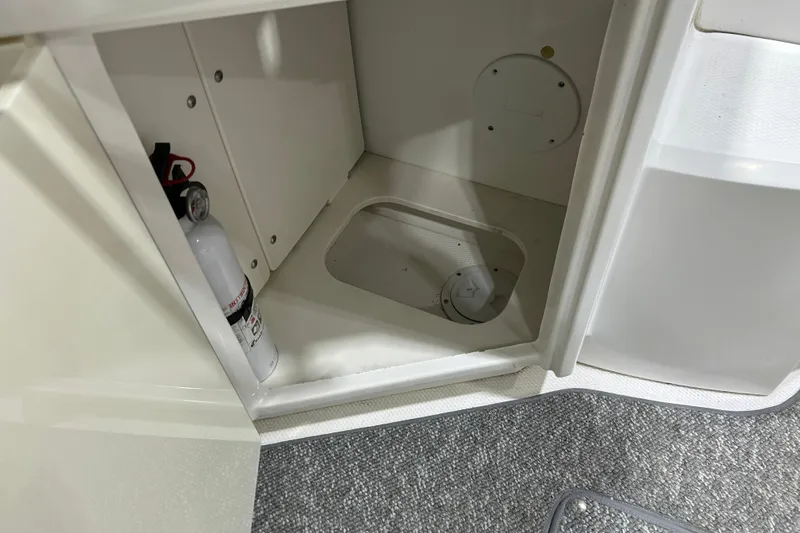 Slide: The Image of Open storage compartment in 2012 Chaparral 327 SSX boat with fire extinguisher. - 89