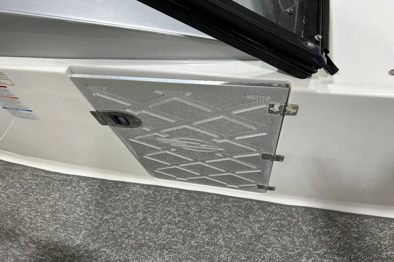 Slide: The Image of 2012 Chaparral 327 SSX boat compartment door with textured metal design. - 92