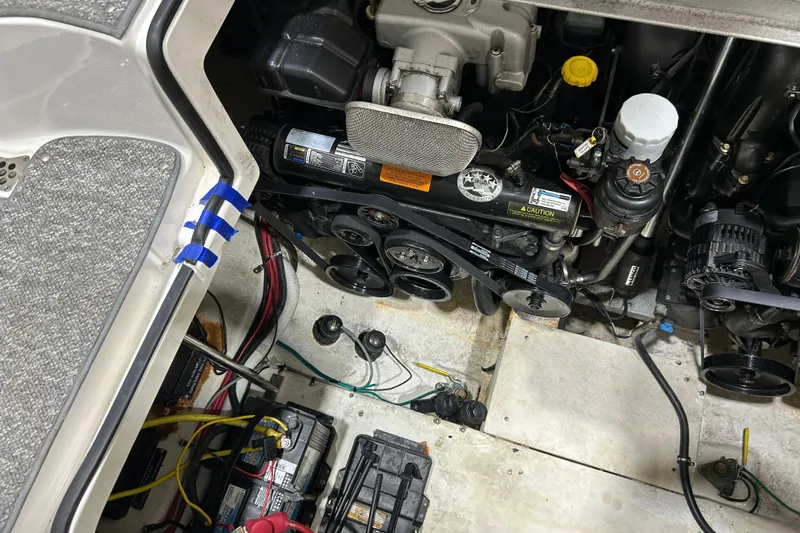 Slide: The Image of Engine compartment of a 2012 Chaparral 327 SSX boat, showing mechanical components and wiring. - 99