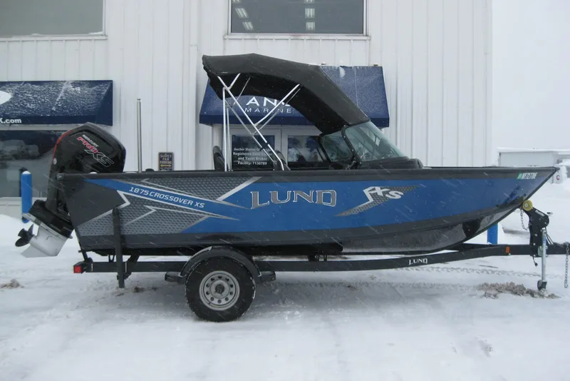 The Image of 2021 Lund 1875 Crossover XS boat on trailer, parked in snowy setting. - 0