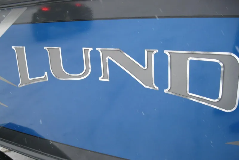 Slide: The Image of Close-up of 2021 Lund 1875 Crossover XS boat logo on blue background. - 2