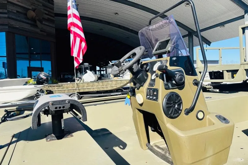 Slide: The Image of 2017 Tracker Grizzly 2072 MVX CC Sportsman boat with steering console and American flag. - 12