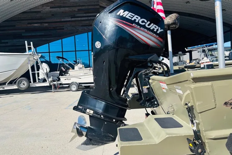 Slide: The Image of 2017 Tracker Grizzly 2072 MVX CC Sportsman with Mercury outboard motor in a marina setting. - 13