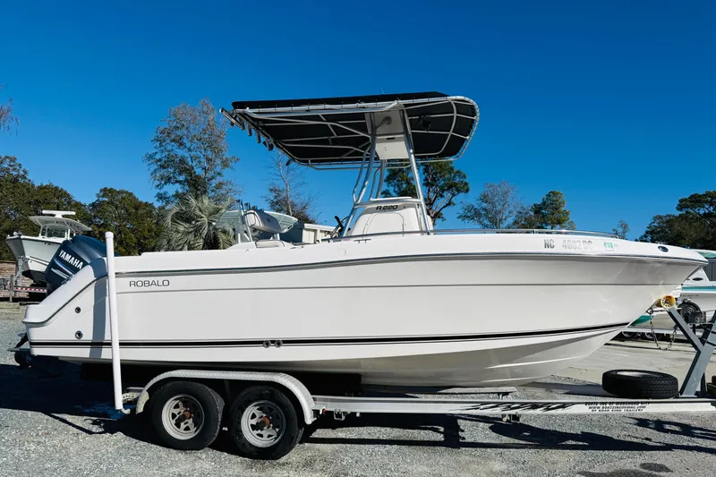 The Image of 2005 Robalo R220 Center Console boat on trailer, clear blue sky background. - 0