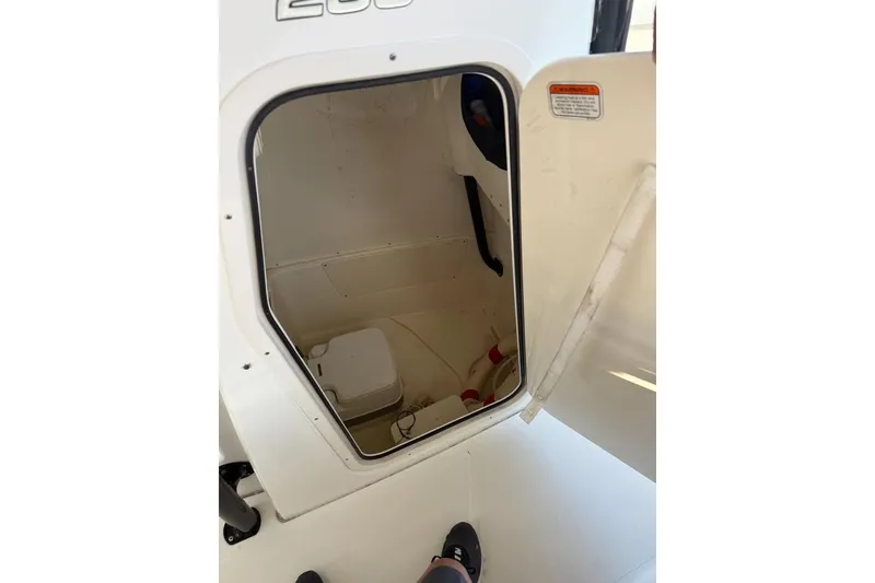 Slide: The Image of Open storage compartment in 2021 Mako 234 Center Console boat. - 12