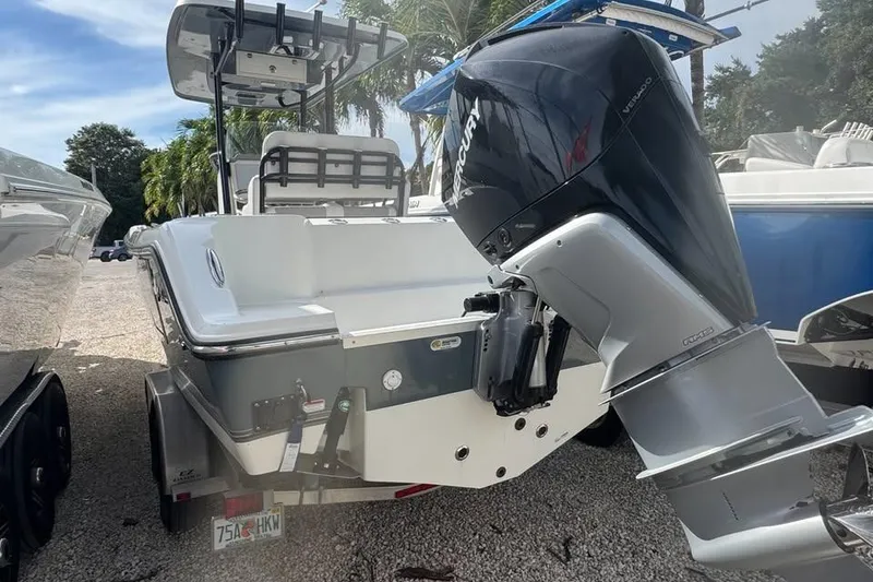 Slide: The Image of 2021 Mako 234 Center Console boat with Mercury outboard motor, parked on gravel. - 4