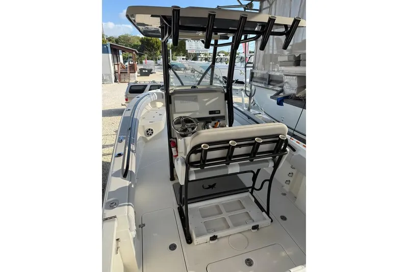 Slide: The Image of 2021 Mako 234 Center Console boat interior with steering wheel and rod holders. - 9