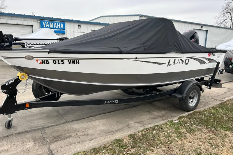 Slide: The Image of 2018 Lund 1775 Impact Sport boat on trailer, covered, parked near Yamaha building. - 11