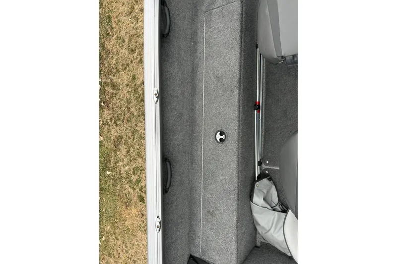 Slide: The Image of 2018 Lund 1775 Impact Sport boat interior with gray carpet and storage compartment. - 15