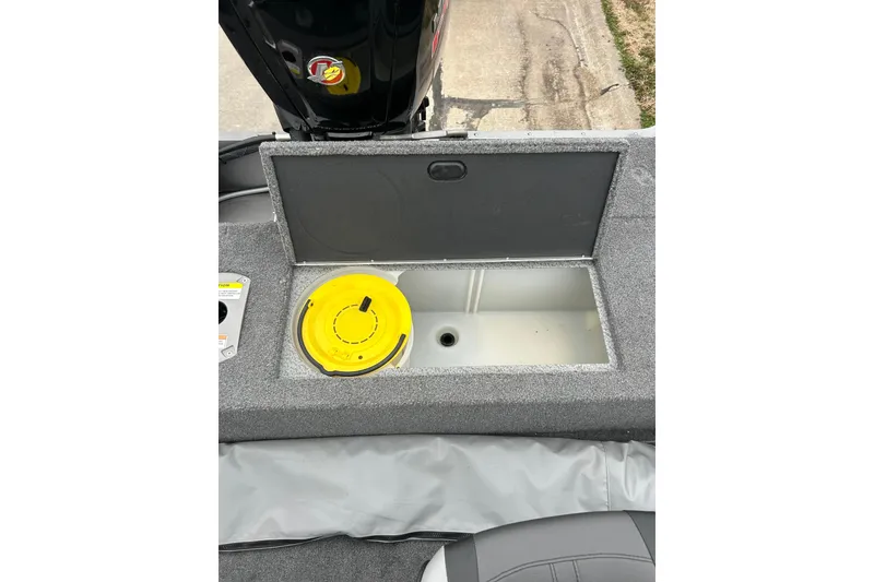 Slide: The Image of 2018 Lund 1775 Impact Sport boat storage compartment with yellow lid and gray interior. - 17
