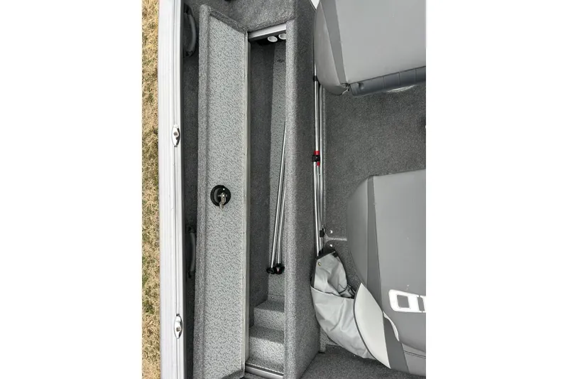Slide: The Image of 2018 Lund 1775 Impact Sport boat interior storage compartment with gray carpet and seating. - 18
