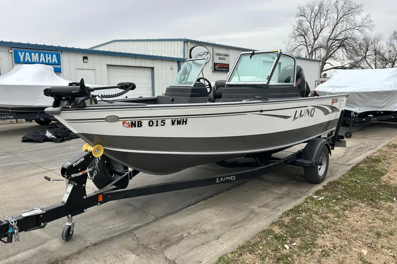 Slide: The Image of 2018 Lund 1775 Impact Sport boat on trailer, parked outside dealership. - 2