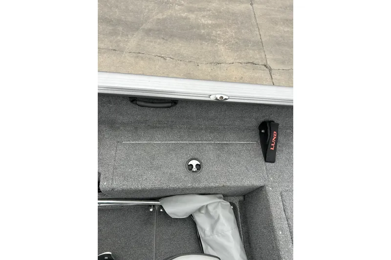 Slide: The Image of 2018 Lund 1775 Impact Sport boat interior with gray carpet and storage compartment. - 24