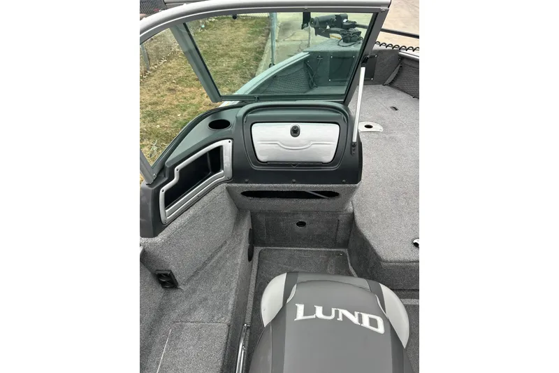 Slide: The Image of 2018 Lund 1775 Impact Sport boat interior with open windshield and storage compartments. - 27