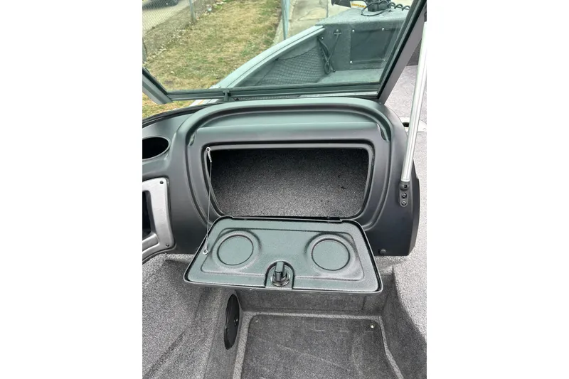 Slide: The Image of 2018 Lund 1775 Impact Sport boat storage compartment with open lid and cup holders. - 29
