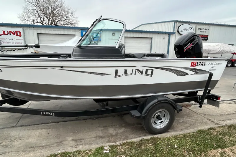 Slide: The Image of 2018 Lund 1775 Impact Sport boat on trailer, parked outside dealership. - 5