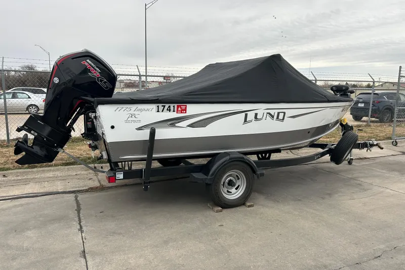 Slide: The Image of 2018 Lund 1775 Impact Sport boat on trailer with cover, parked outdoors. - 8