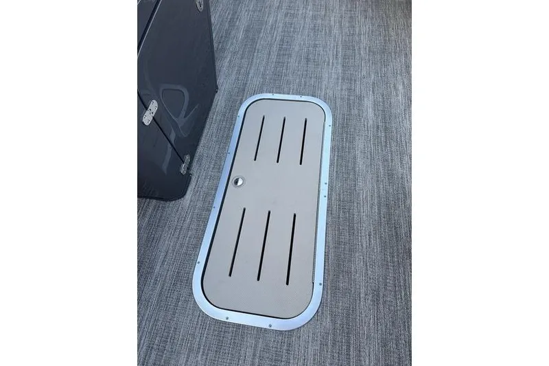 Slide: The Image of 2026 Bennington S Swingback 23 SSB ESP boat floor hatch on textured surface. - 18