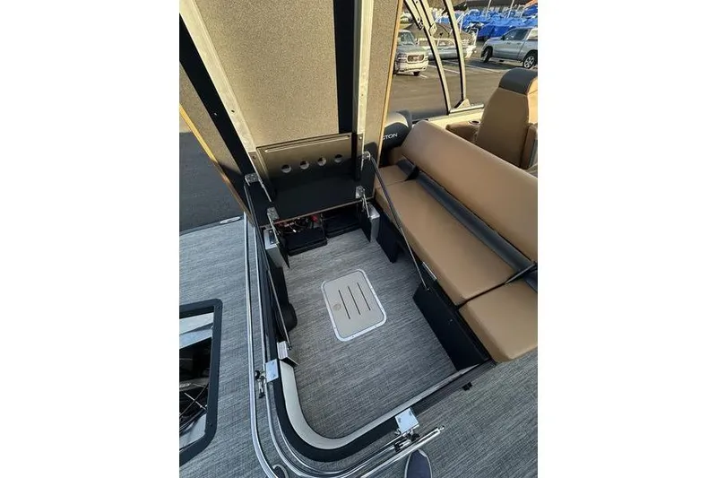 Slide: The Image of 2026 Bennington S Swingback 23 SSB ESP interior with tan seating and storage area. - 26