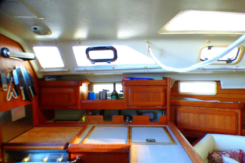 Slide: The Image of Interior of 1994 Hunter Legend 35.5 sailboat, featuring wooden cabinetry and kitchen area. - 11