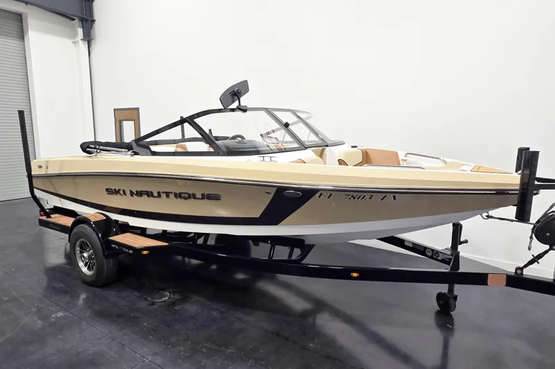 Slide: The Image of 2025 Nautique Ski Nautique boat on trailer in indoor showroom. - 3