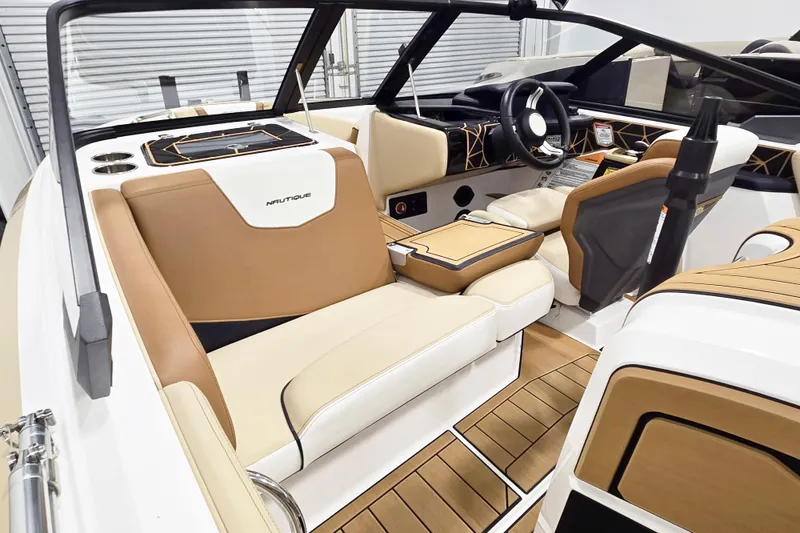 Slide: The Image of 2025 Nautique Ski Nautique interior with tan and white seating, modern dashboard, and wood accents. - 9