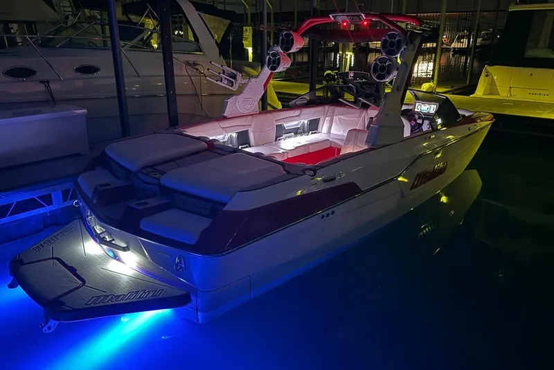 Slide: The Image of 2021 Malibu M240 boat with illuminated interior and exterior, docked at night. - 45
