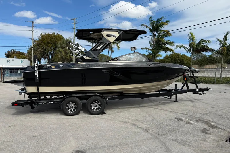 Slide: The Image of 2026 Centurion Ri230 boat on trailer, parked outdoors under a clear sky. - 10