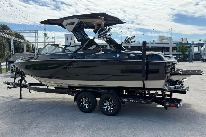 Slide: The Image of 2026 Centurion Ri230 boat on trailer, sleek black design, parked outdoors. - 3