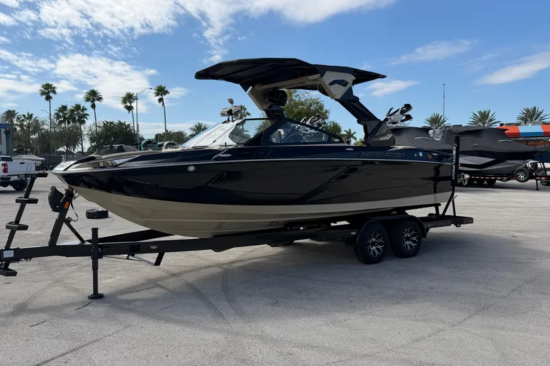 Slide: The Image of 2026 Centurion Ri230 boat on trailer, parked outdoors under a clear sky. - 4