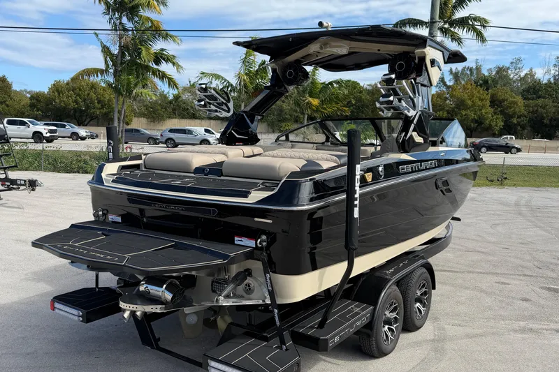 Slide: The Image of 2026 Centurion Ri230 boat on trailer, sleek black design, parked outdoors. - 6